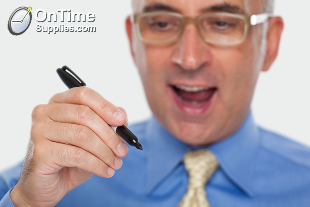 Man holding a pen to a glass board
